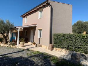 a house with a hedge in front of it at Domu Quesada in San Giovanni Suèrgiu