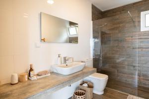 a bathroom with a sink and a toilet and a mirror at Yeotown Health Retreat in Arco da Calheta