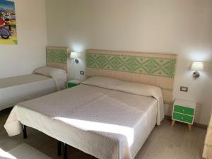 um pequeno quarto com 2 camas e 2 candeeiros em Domu Quesada em San Giovanni Suergiu