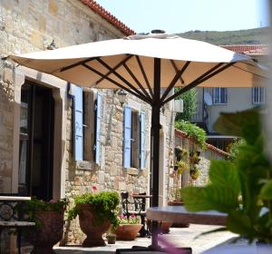 an umbrella sitting on a patio in front of a building at Griffon Hotel in Yenifoça