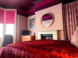 a bedroom with a bed and a mirror and a fireplace at Snooze in Brighton & Hove