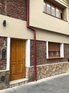 un edificio con una puerta de madera en su lateral en Center en Esquel