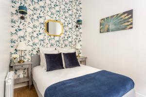 ein Schlafzimmer mit einem Bett mit einer blauen Decke in der Unterkunft Cosy 3 bedroom and 2 Bathroom - Opera in Paris