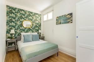 Schlafzimmer mit einem Bett mit Blumentapete in der Unterkunft Cosy 3 bedroom and 2 Bathroom - Opera in Paris