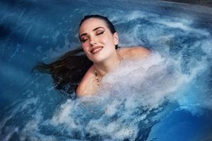 Anixi Hotel by AP في أثينا: امرأة مستلقية في حوض الاستحمام مع الماء
