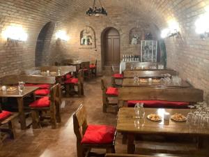 a restaurant with wooden tables and chairs and a brick wall at Vinný sklep u Křížů in Milotice