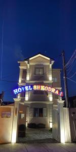 a house with a neon sign in front of it at Hotel Shkodra L in Shkodër