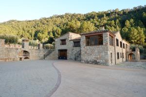 a large stone building with a large driveway at Mas de la Vall del Frare in Gandesa
