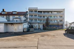 un parking en face d'un grand bâtiment dans l'établissement Huber Living Basic 203, à Germering