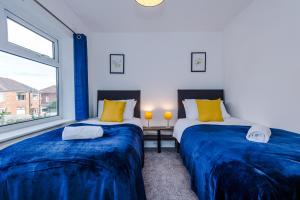 Duas camas num quarto com almofadas azuis e amarelas em Half mile to Etihad Stadium & Coop arena, free parking, 6 ppl em Manchester