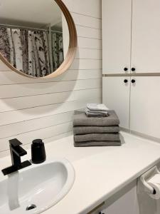 a white bathroom with a sink and a mirror at Loft LèSKImo, lit king, sauna, piscine et montagne in Saint-Férréol-les-Neiges