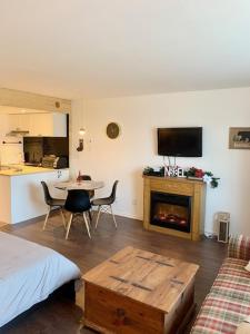 um quarto com uma cama, uma mesa e uma lareira em Loft LèSKImo, lit king, sauna, piscine et montagne em Saint-Férréol-les-Neiges