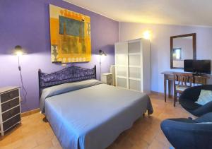 um quarto com uma cama, uma cadeira e uma secretária em Bio Agriturismo Valle dei Calanchi em Castiglione in Teverina