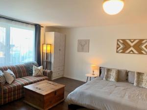 uma sala de estar com uma cama e um sofá em Loft LèSKImo, lit king, sauna, piscine et montagne em Saint-Férréol-les-Neiges