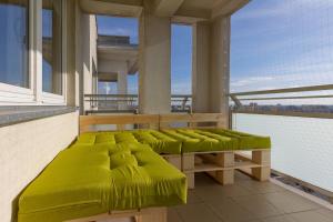 a balcony with green cushioned beds on a building at Mokotów Unique & Pet-Friendly Apartment by Renters in Warsaw