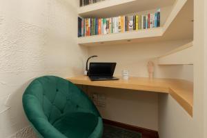 a green chair sitting next to a desk with a laptop at Mokotów Unique & Pet-Friendly Apartment by Renters in Warsaw