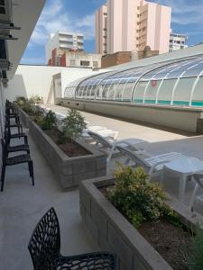 a group of chairs and tables on a patio at Apart Casa De Playa Premium in Necochea