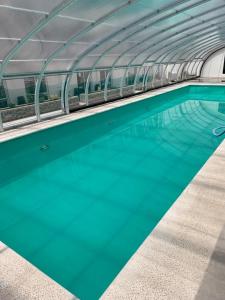 una piscina de agua azul en un edificio en Apart Casa De Playa Premium en Necochea