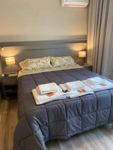 a bedroom with a bed with towels on it at Apart Casa De Playa Premium in Necochea +18 photos