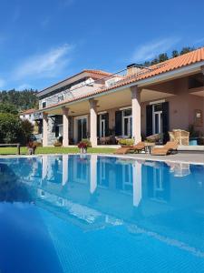 a swimming pool in front of a house at Yeotown Health Retreat in Arco da Calheta