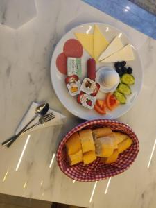 una mesa con dos platos de queso y un plato de fruta en Luxury Airport Hotel, en Arnavutköy