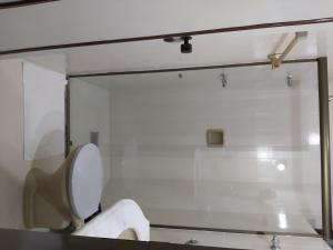 a bathroom with a toilet and a glass window at Hotel Village Cataguases in Cataguases