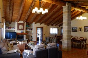 a living room with couches and a tv and a fireplace at Mas de la Vall del Frare in Gandesa