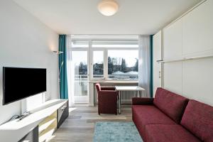 een woonkamer met een rode bank en een tv bij Huber Living Basic 205 in Germering