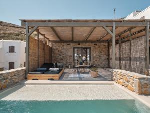 un pavillon avec une piscine et une terrasse dans l'établissement Amal Kythnos Suites, à Kythnos
