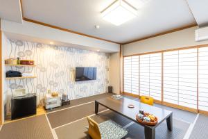 a living room with a table and a tv at Yoshino in Ito