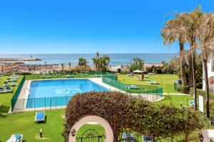 una vista de una piscina y la playa en A24 Cabopino, en Marbella