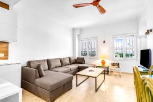 Una sala de estar con un sofá y un televisor. en A24 Cabopino, en Marbella