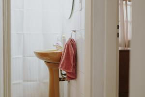 baño con lavabo y toalla roja en Leguizamon Flat - MZA Travel en Godoy Cruz