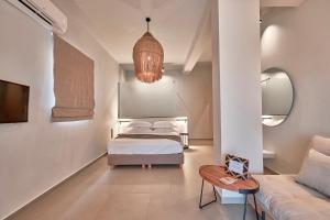 - une chambre avec un lit et un canapé dans l'établissement Amal Kythnos Suites, à Kythnos