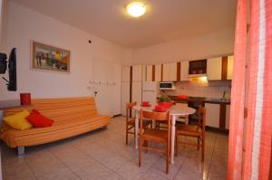 a kitchen and a living room with a couch and a table at Appartamenti Foyer in Bibione