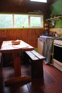 a kitchen with a wooden table and a stove at La Colorida in Lago Puelo
