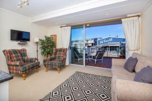 a living room with a couch and chairs and a balcony at Sheer Nest in Knysna