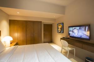 a hotel room with a large bed and a flat screen tv at Silalima in Kuantan