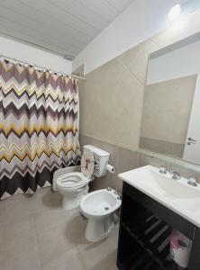 une salle de bain avec toilettes, lavabo et miroir dans l'établissement Pueblo Nuevo, à Junín