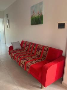 un sofá rojo con una manta en una habitación en Pueblo Nuevo en Junín