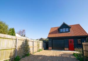 a house with a red door and a fence at Swift Lodge in Kirton