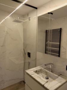 ein Bad mit einem Waschbecken und einem Spiegel in der Unterkunft Riva Bella 1.01 in Nieuwpoort