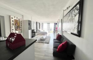 a living room with a black couch and red pillows at Luxurious studio suite near Monaco with sea view in Éze