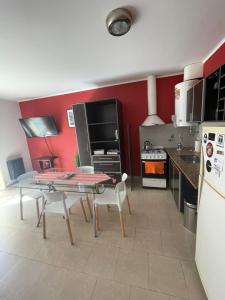 une cuisine avec des murs rouges et une table et des chaises dans l'établissement Pueblo Nuevo, à Junín 8 autres photos