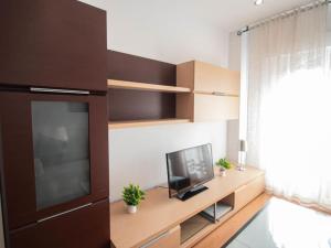 ein Wohnzimmer mit einem TV auf einem Holztisch in der Unterkunft Armilla Apartament by A3Rentals in Armilla