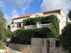 a house with ivy growing on a stone wall at Apartments Katarina in Vis