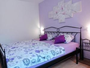 um quarto com uma cama com lençóis e almofadas roxos em Apartments Katarina em Vis