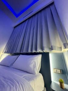 ein Schlafzimmer mit einem Bett mit blauer Decke in der Unterkunft I Cappuccini Suite in Palermo
