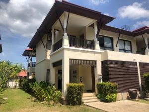 a large white house with a balcony at Pool Villa Phuket 2 bedroom in Layan Beach