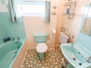 a bathroom with a toilet and a tub and a sink at Bosworlas Farm House in Penzance +26 photos